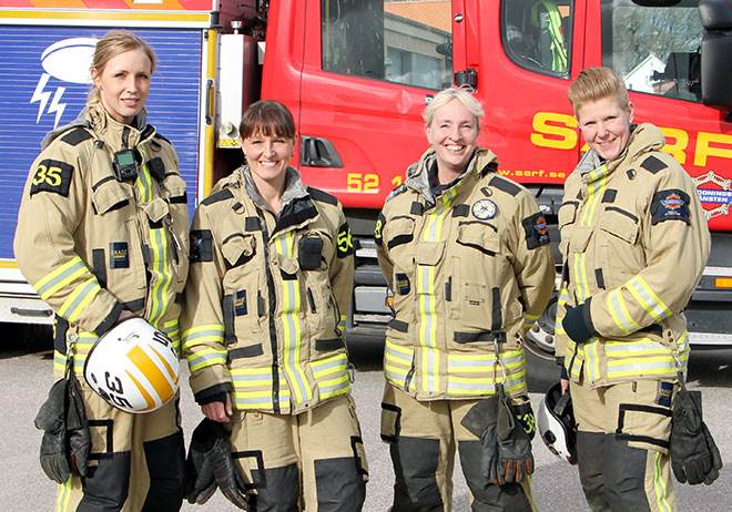 Foto på fyra kvinnliga brandmän som ler mot kameran