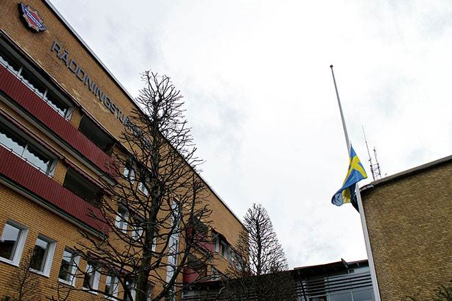 Foto på svenska flaggan som halats till halv stång utanför Borås brandstation.